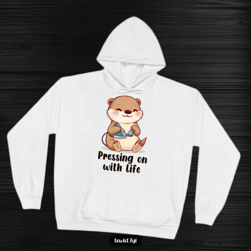 Funny otter ironing hoodie, a content creature happily pressing a seam with a tiny iron, ideal for cozy crafting and as a humorous gift.