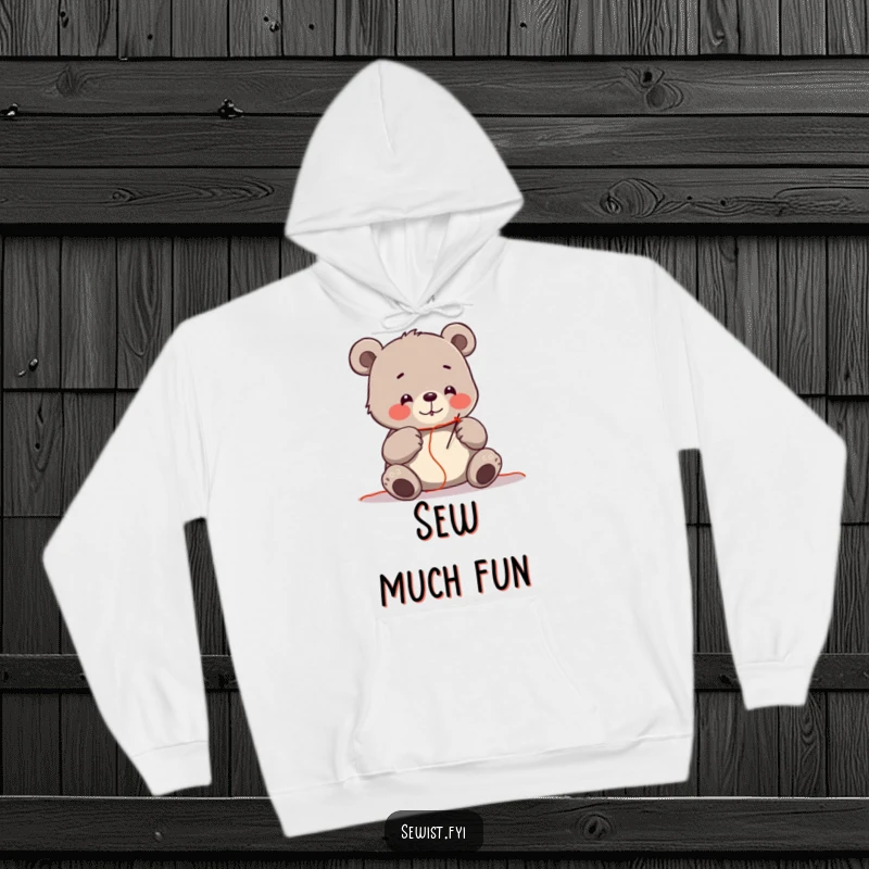 Funny hoodie featuring a cheerful bear meticulously threading a needle with bright red thread, symbolizing focus.