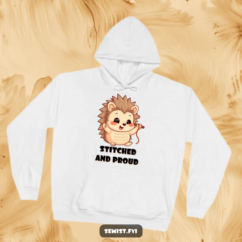Funny Hedgehog Hoodie: A smiling hedgehog character holding up a completed stitch, embodying crafting joy.